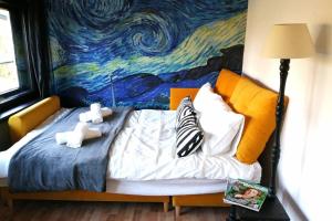 a bed with two teddy bears on it in front of a painting at Koci Dom in Wieliczka