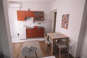 a small kitchen with a table and a table and chairs at De lux Apartment & Rooms Emilia in Banja Luka