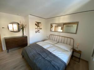 1 dormitorio con cama, tocador y espejo en Haus Ingrid, en Kitzbühel
