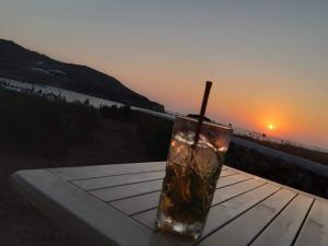a drink sitting on a table with the sunset in the background at Sunset Studios & Rooms in Antiparos