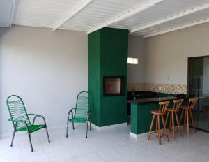 a room with four chairs and a green wall at Atlantico Residencial in Bonito