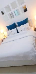 a bedroom with a large white bed with blue pillows at Charming Luxury Room 10 Min from the Old City in Jerusalem