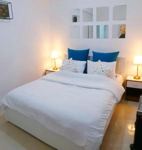 um quarto com uma grande cama branca com almofadas azuis em Charming Luxury Room 10 Min from the Old City em Jerusalém