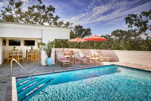 a swimming pool with chairs and a table and umbrella at Hotel Simone in Saint Simons Island