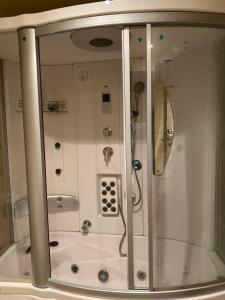 a bathroom with a shower stall and a tub at Bollywood Beach Hostel in Dubai