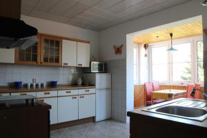 cocina con armarios blancos y nevera blanca en Ferienwohnung Halberstadt, en Halberstadt