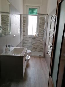 baño con lavabo y aseo y ventana en Antonella's House, en Vasto