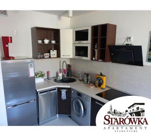 a kitchen with a refrigerator and a washing machine at STARÓWKA Apartament Stare Tychy in Tychy
