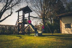 duas crianças a brincar num escorrega num parque infantil em Le Vigne Morosina em Cessalto