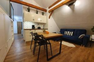 a living room with a table and a blue couch at Koci Dom Loft in Wieliczka