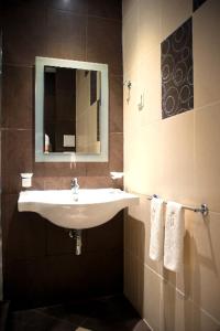 a bathroom with a sink and a mirror and towels at Hotel Victoria in Panagyurishte