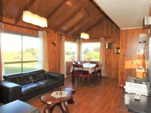 a living room with a black leather couch and a table at Casa Amoblada Frutillar in Frutillar