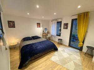 a bedroom with a bed with a blue comforter at Joli appartement avec cour privée proche gare & centre ville in Rouen