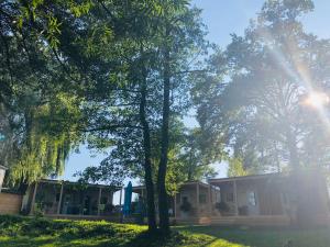 una casa con árboles delante de ella en Holiday resort & camping Bela krajina - river Kolpa en Metlika