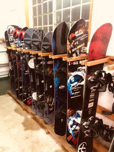 a row of snowboards lined up on a rack at SnowHouse Memorie Hotel-石打丸山 in Seki