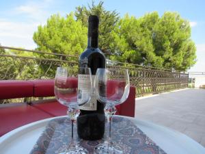 a bottle of wine sitting on a table with two glasses at Villa Il Giovane Alloro in Martina Franca +11 photos