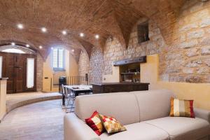 a living room with a couch and a stone wall at another brick in the vault in Spello