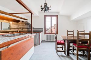 eine Küche mit einem Tisch und einem Esszimmer in der Unterkunft Ponte di Rialto Penthouse with Panoramic Terrace in Venedig