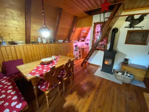 a dining room with a table and a wood stove at Wooden Cottage in Jesenice