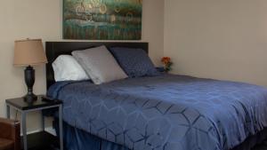 a bed with a blue comforter in a bedroom at Mark III, INN & Suites in Scottdale