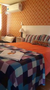 1 dormitorio con 1 cama con una manta colorida en Cascadas Departamentos en Córdoba