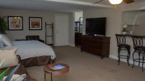 a bedroom with a bed and a flat screen tv at Mark III, INN & Suites in Scottdale