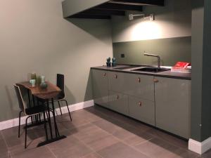 a kitchen with a sink and a counter with a table at Cortile Umberto in Racalmuto