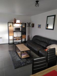 - un salon avec un canapé en cuir et une table basse dans l'établissement Chez Marie et christian, à La Boussac