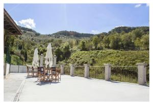 eine Terrasse mit Tischen, Stühlen und Sonnenschirmen in der Unterkunft Casa Rural Manuel de Pepa Xuaca in Tuilla