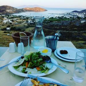 a table with plates of food and a view of the ocean at Serifos Summer Dream House in Serifos Chora