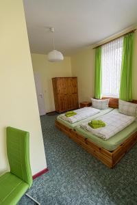 1 dormitorio con 2 camas y una ventana con cortinas verdes en Ski und Biker Hotel Villa Sonnenschein Braunlage am Wurmberg en Braunlage