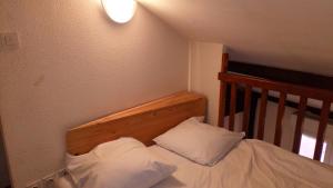 un lit avec deux oreillers blancs dans une chambre dans l'établissement Résidence le Pastel François Verdier, à Toulouse