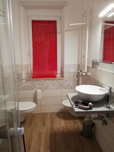 a bathroom with a sink and a red window at LA PECORA NERA in Rome