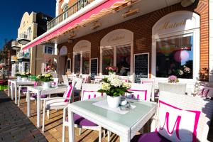 a row of tables and chairs in front of a restaurant at La Maison M in Westerland (Sylt)