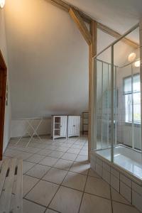 ブラウンラーゲにあるHotel Villa Sonnenscheinのガラスの壁とベンチが備わる広い客室です。