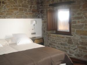 Schlafzimmer mit einem Bett und einem Fenster in der Unterkunft Casa Rural Manuel de Pepa Xuaca in Tuilla