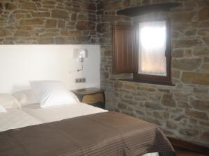 ein Schlafzimmer mit einem Bett und einem Fenster in der Unterkunft Casa Rural Manuel de Pepa Xuaca in Tuilla