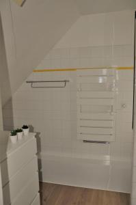 a white tiled bathroom with two potted plants at Le 246 - Duplex face à la mer pour 4 personnes, Wifi, TV full Sat, Parking in Wimereux