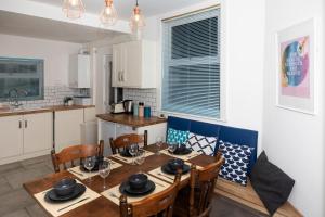 a dining room with a table and chairs and a kitchen at Arthouse - Lovely, Spacious and Elegant 5bed House in Nottingham