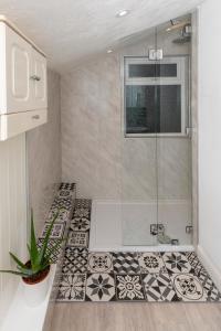 y baño con ducha y azulejos blancos y negros. en Arthouse - Lovely, Spacious and Elegant 5bed House en Nottingham
