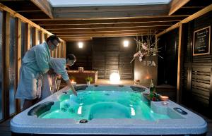 a woman standing in front of a bath tub at Les Béthunoises Centre Grand-Place - Spa et Sauna in Béthune