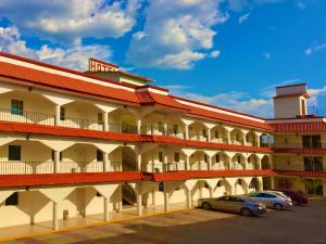 ein großes Gebäude mit Autos auf einem Parkplatz in der Unterkunft Hotel Go Inn in Monclova