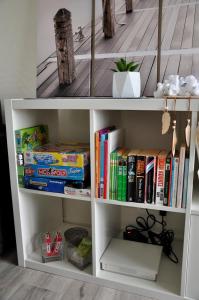 a white book shelf with books on it at Le 246 - Duplex face à la mer pour 4 personnes, Wifi, TV full Sat, Parking in Wimereux