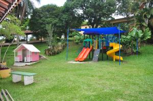 a playground with a slide in a yard at Resort Recanto do Teixeira All Inclusive in Nazaré Paulista