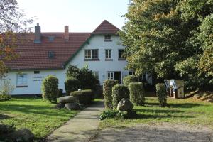 una casa blanca con un camino delante de ella en Landhaus Alt Reddevitz, en Middelhagen