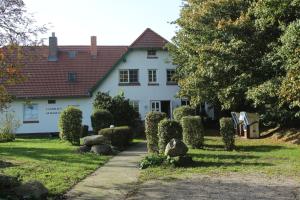 a white house with a pathway in front of it at Landhaus Alt Reddevitz in Middelhagen