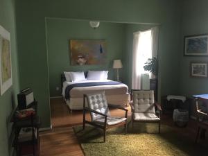 um quarto com uma cama e duas cadeiras em Casa Piabanha - Centro Histórico em Petrópolis