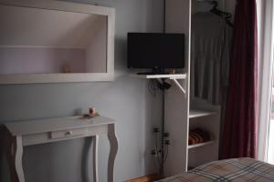 a bedroom with a tv and a desk and a bed at Agroturystyka SZYSZKA in Polnica