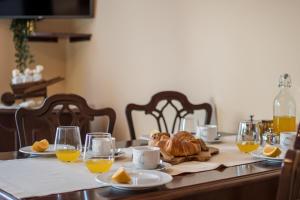 a table with a breakfast of croissants and orange juice at Apartments Viler in Buje