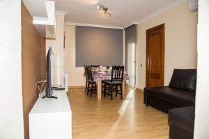 ein Wohnzimmer mit einem Sofa und einem Tisch mit Stühlen in der Unterkunft Apartamento Reus 1 - Parking gratuito in Reus